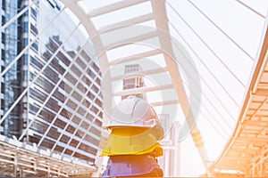 Stack of blue, yellow, white hard safety helmet on concrete floor in construction site. Personal protective equipment hat for