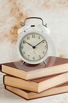 Stack of Books with Alarm Clock. Time for reading, concentration in study, homework or educational concept. Copy space