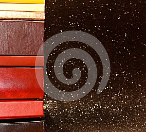 A stack of books on a black background. Many colorful books. Books in a long row