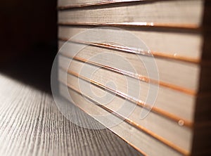 Stack of books on black table and light from sun