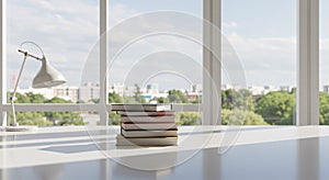 Stack of Books on a Bright Desk with a Large Window View