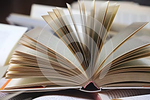 stack of books, close up. Open book on the table in library. Back to school concept.