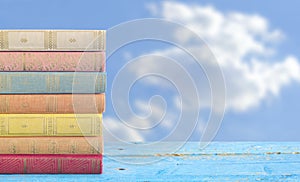 Stack of books on cloudy blue sky background,copy space