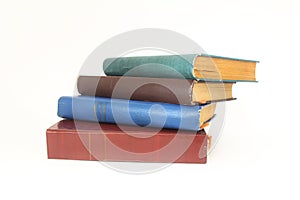 Stack of books in colour covers with white sheets isolated on a white background