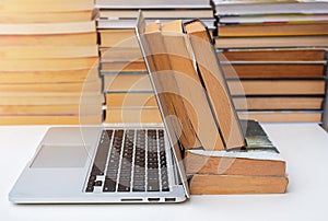 Stack of books and a computer on the table