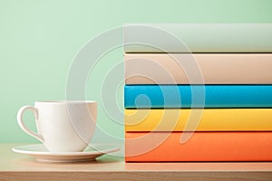 Stack of books and cup on wooden table