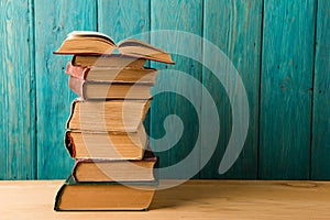 stack of books on the desk over wooden background