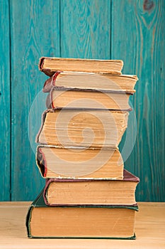 stack of books on the desk over wooden background