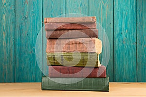 stack of books on the desk over wooden background