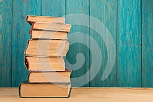 stack of books on the desk over wooden background