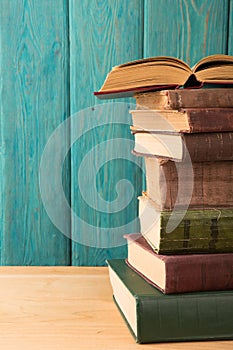 stack of books on the desk over wooden background