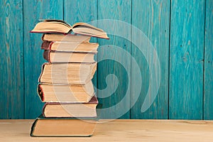 stack of books on the desk over wooden background