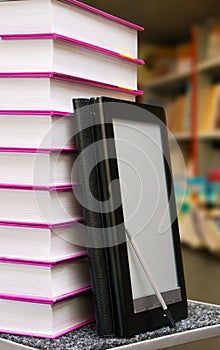 Stack of books with e-book reader