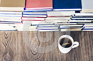 Stack of books education background, many books piles and cup of tea with lemon
