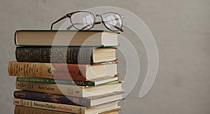 Stack of Books with Glasses on Top in Neutral Setting