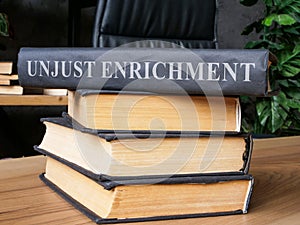 Stack of books with a law about unjust enrichment on it. photo