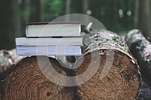 A stack of books lying on the logs, save trees - read ebooks co