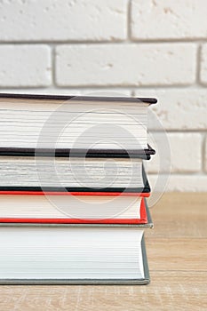 Stack of books in multi-colored covers on a wooden table