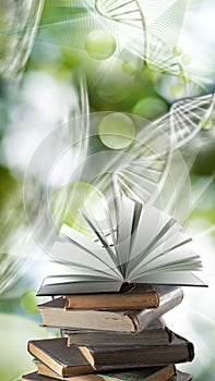 Stack of books and an open book on a stack against the background of stylized DNA chains