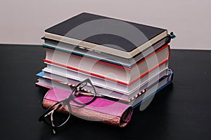 Stack of books with a pair of glasses