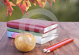 stack of books, pencils and yellow apple. Series back to school.