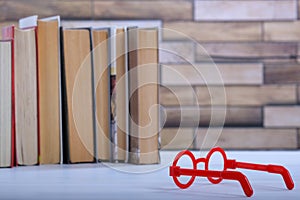 Stack with books and red glasses on the table, education concept, background