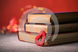 Stack of books and red heart. Romantic background with the book