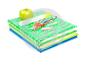 Stack of books with school suppley and green apple