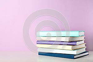 Stack of books on shelf against color background