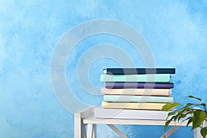 Stack of books on shelf against color background