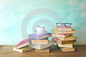 Stack of books with spectacles and cup of coffee
