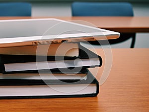 Stack of books and tablet on the table.