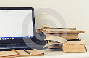 Stack of books, textbook, laptop, glasses in office business background for education learning concept.