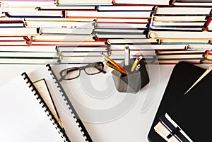 Stack of books, textbook, laptop, glasses in office business background for education learning concept