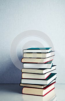 Stack of books on white reflective surface
