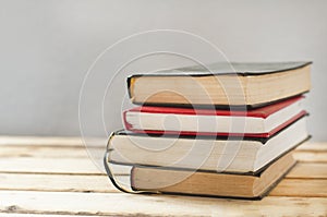 A stack of books on a wooden table.