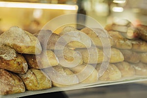 Stack of bread loaves are displayed in bakery shop window