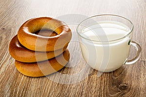 Stack of bread rings baranka, cup with milk on table photo
