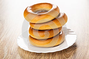 Stack of bread rings baranka in plate  on wooden table photo
