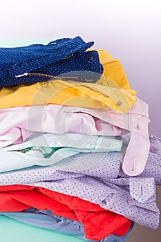 Stack of bright female trousers. Folded colorful pants and jeans. Close up