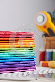 Stack of bright multicolored fabrics, accessories for sewing and quilting