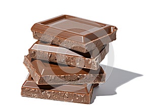 A stack of broken milk chocolate on a white isolated background, square pieces