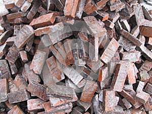 Stack of broken red bricks on the ground, old bricks texture background