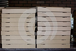 Stack of brown pizza boxes in pizzeria
