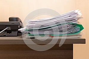 Stack of business documents on wooden office desk.Concept of business,working place,overworking.Paper files is near black
