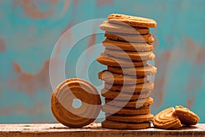 Stack of butter cookies/biscuits on wooden board with teal green rustic background