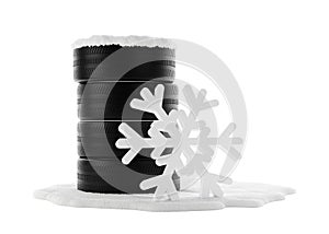 Stack of car tires covered with snow on snow patch over white background with abstract snowflake standing next to it, winter tire