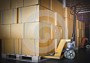 Stack of Card Board Boxes with Hand Pallet Truck. Interior of Storage Warehouse. Cargo Shipment Export- Import.