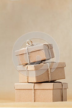 Stack of cardboard boxes on the brown recycled paper background tied with a rope