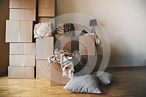 Stack of cardboard boxes and decorative house objects in new apartment. Moving day